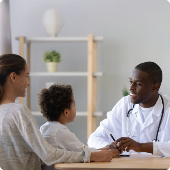 Médico conversando com paciente e familiar durante consulta, representando o cuidado e acompanhamento do Programa FazBem